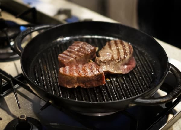 鉄フライパンで肉を焼く