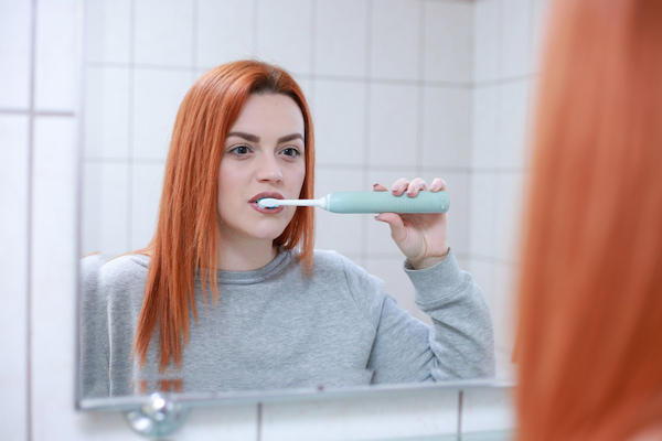 電動歯ブラシを使っている女性