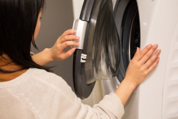 洗濯機のフタを閉める女性