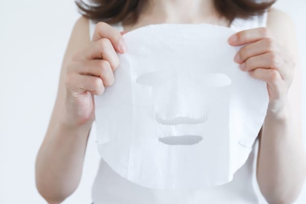 シートマスクを持つ女性
