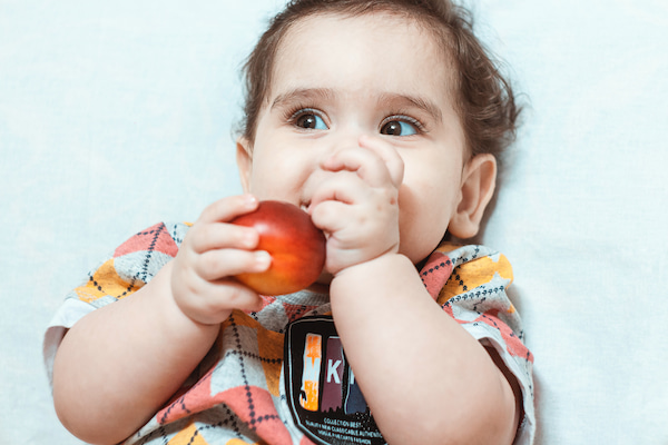 りんごを自分で食べる赤ちゃん