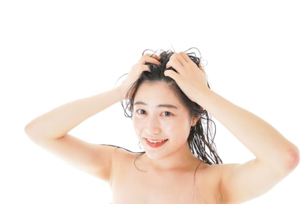 濡れた髪の毛を押さえる女性