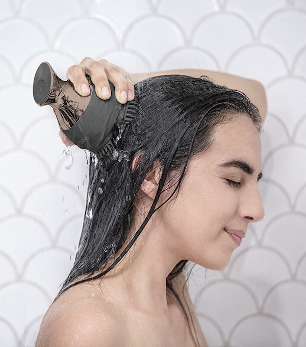 シャワー中に頭皮マッサージ器を使う女性