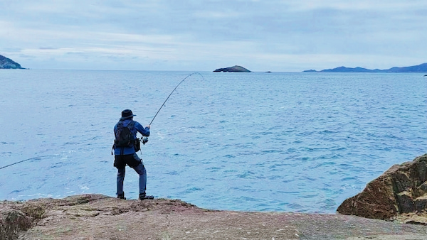 磯で釣りをする人