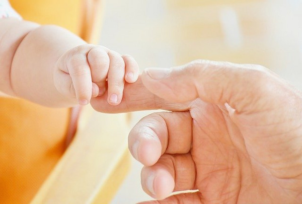 指で握手する親子の手