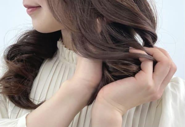 ムースを毛先に揉み込む女性