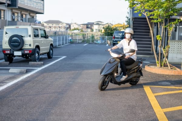 原付きバイクで走行中の女性